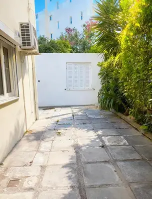 a stone walkway in front of a white wall at sea soul house in Athens