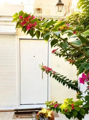 a white garage door with pink flowers on it at sea soul house in Athens