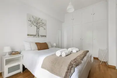 a white bedroom with a bed with towels on it at Serenity - 1-BR Apartment in Zografou in Athens