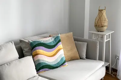 a living room with a couch with a colorful pillow at Serenity - 1-BR Apartment in Zografou in Athens