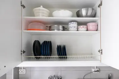 a kitchen cabinet filled with dishes and bowls at Serenity - 1-BR Apartment in Zografou in Athens