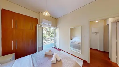a bedroom with a large bed and a large window at Prigipos Petrou Cozy Apartment Glyfada in Athens