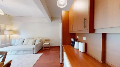 a living room with a white couch and a table at Prigipos Petrou Cozy Apartment Glyfada in Athens
