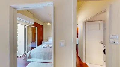 a room with two beds and a door to a bedroom at Prigipos Petrou Cozy Apartment Glyfada in Athens
