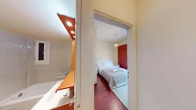 a bedroom with a bed and a tub and a bathroom at Prigipos Petrou Cozy Apartment Glyfada in Athens