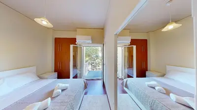 two beds in a room with two mirrors at Prigipos Petrou Cozy Apartment Glyfada in Athens