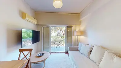 a living room with a couch and a table at Prigipos Petrou Cozy Apartment Glyfada in Athens