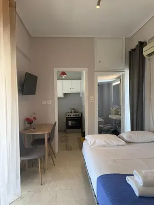 a room with two beds and a table and a kitchen at Beautiful apartment in Petralona in Mesochórion