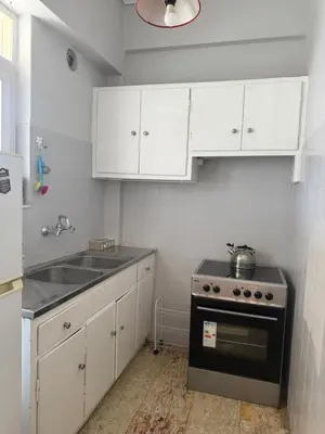 a kitchen with white cabinets and a sink and a stove at Beautiful apartment in Petralona in Mesochórion