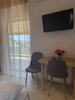 a room with a table and two chairs and a television at Beautiful apartment in Petralona in Mesochórion
