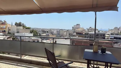 a table and chairs on a balcony with a view of a city at Beautiful apartment in Petralona in Mesochórion