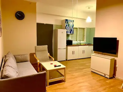 a living room with a couch and a tv and a kitchen at 1bedroom 300 meter Dafni metro in Athens