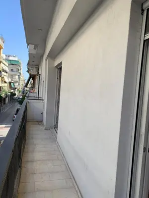 an empty sidewalk next to a building with a window at 1bedroom 300 meter Dafni metro in Athens