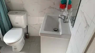 a white bathroom with a toilet and a sink at 1bedroom 300 meter Dafni metro in Athens