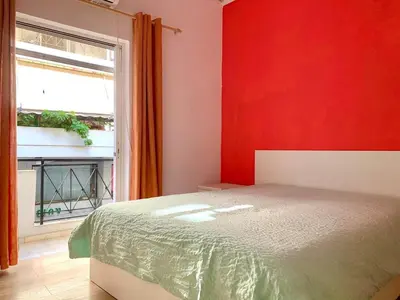 a red bedroom with a bed and a window at 1bedroom 300 meter Dafni metro in Athens