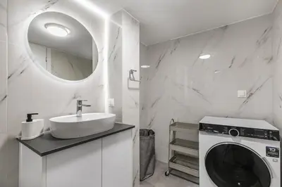 a bathroom with a washing machine and a sink at Artsi - Vibrant 3-BR Apartment & Balcony in Athens in Athens