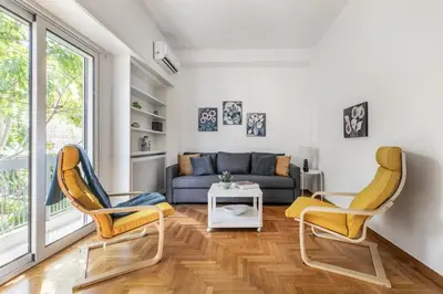 a living room with two chairs and a couch at Artsi - Vibrant 3-BR Apartment & Balcony in Athens in Athens