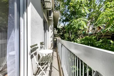 a balcony with a chair sitting on a porch at Artsi - Vibrant 3-BR Apartment & Balcony in Athens in Athens