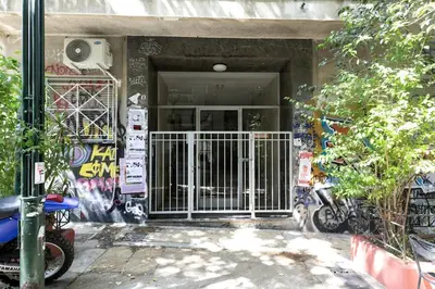 a building with a gate in front of a building with graffiti at Artsi - Vibrant 3-BR Apartment & Balcony in Athens in Athens