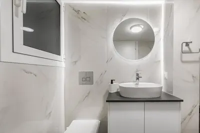a white bathroom with a sink and a mirror at Artsi - Vibrant 3-BR Apartment & Balcony in Athens in Athens