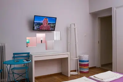 a room with a desk with a tv on the wall at Athens Charm in Athens