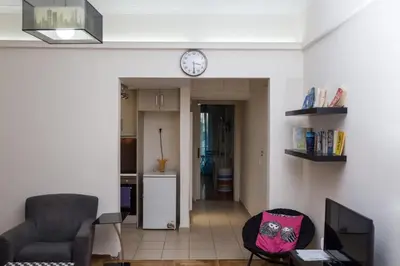 a living room with a couch and a clock on the wall at Athens Charm in Athens