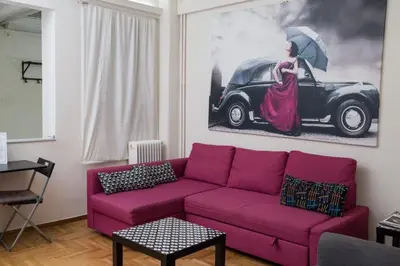 a living room with a purple couch and a painting at Athens Charm in Athens