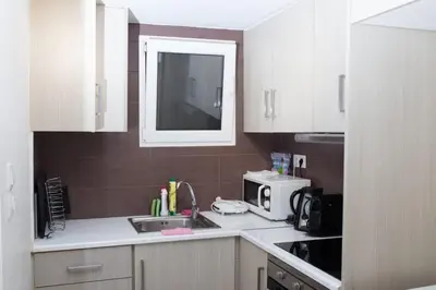a kitchen with white cabinets and a sink and a microwave at Athens Charm in Athens
