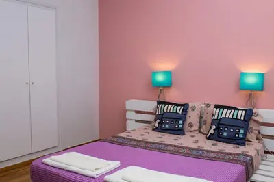 a bedroom with a bed with purple sheets and two lamps at Athens Charm in Athens