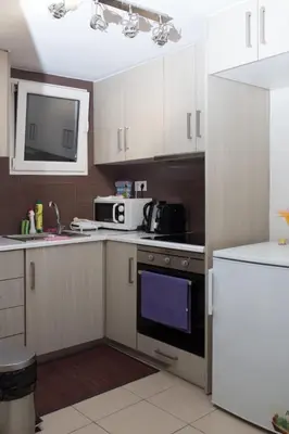 a kitchen with white cabinets and a stove top oven at Athens Charm in Athens