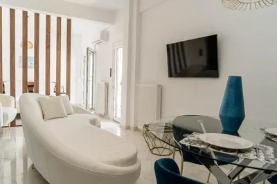 a living room with a white couch and a glass table at One&Only apartment in Athens