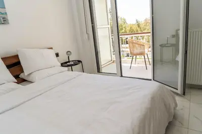 a white bed in a room with a balcony at One&Only apartment in Athens