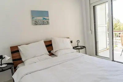 a white bedroom with a bed with white sheets and pillows at One&Only apartment in Athens