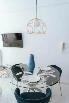 a dining room with a glass table and blue chairs at One&Only apartment in Athens