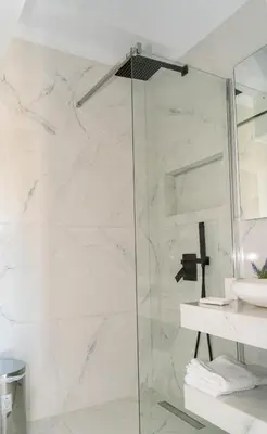 a bathroom with a glass shower with a sink at One&Only apartment in Athens