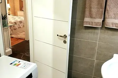 a bathroom with a white door and a toilet at Four Seasons Cozy Apartment Paleo Faliro South Ath in Athens