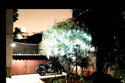 a motorcycle parked in a yard next to a fence at Four Seasons Cozy Apartment Paleo Faliro South Ath in Athens