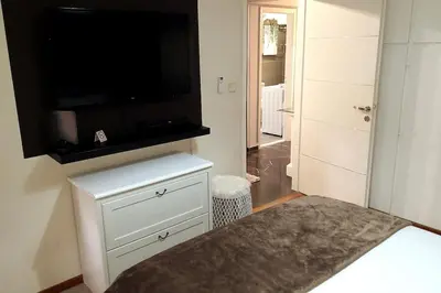 a bedroom with a flat screen tv on a wall at Four Seasons Cozy Apartment Paleo Faliro South Ath in Athens