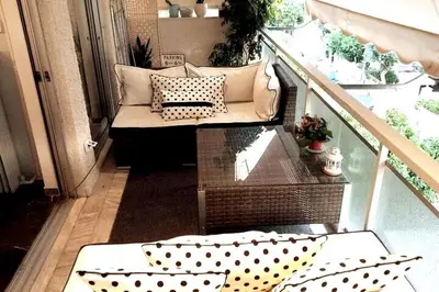 a balcony with a couch and pillows on a porch at Four Seasons Cozy Apartment Paleo Faliro South Ath in Athens