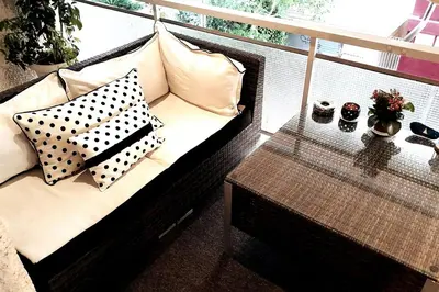 a couch with pillows on a balcony with a table at Four Seasons Cozy Apartment Paleo Faliro South Ath in Athens