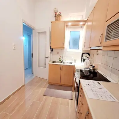 a kitchen with wooden cabinets and a sink at Iris' Home in Piraeus