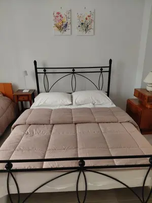 a large bed with a black frame in a bedroom at Iris' Home in Piraeus