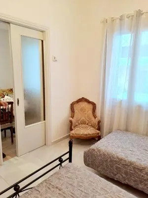 a bedroom with a chair and a bed and a window at Iris' Home in Piraeus