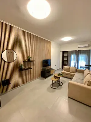 a large living room with a couch and a tv at Filolaou New Beautiful Apartment in Athens