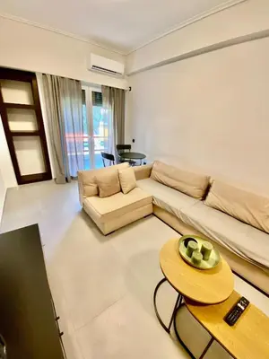 a living room with a couch and a table at Filolaou New Beautiful Apartment in Athens
