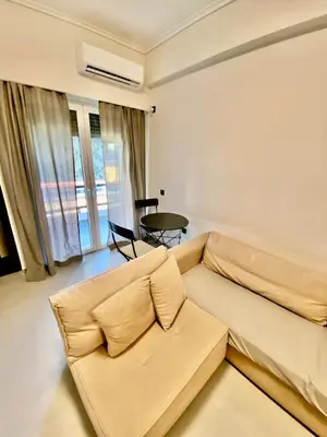 a living room with a couch and a table at Filolaou New Beautiful Apartment in Athens