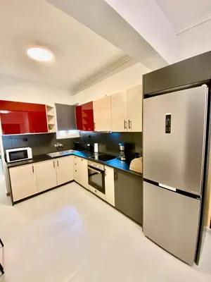 a kitchen with red and white cabinets and a refrigerator at Filolaou New Beautiful Apartment in Athens