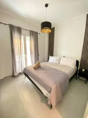 a bedroom with a bed with a teddy bear on it at Filolaou New Beautiful Apartment in Athens