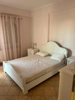 a bedroom with a white bed with a white headboard at Villa Clio in Porto Rafti