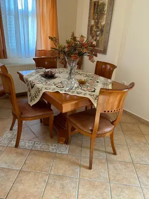 a dining room table with a vase of flowers on it at Villa Clio in Porto Rafti